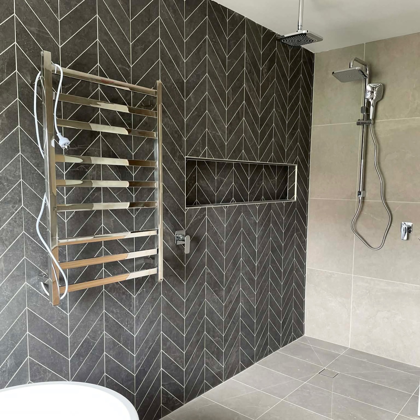 Chevron-tiled walk-in shower with rainhead