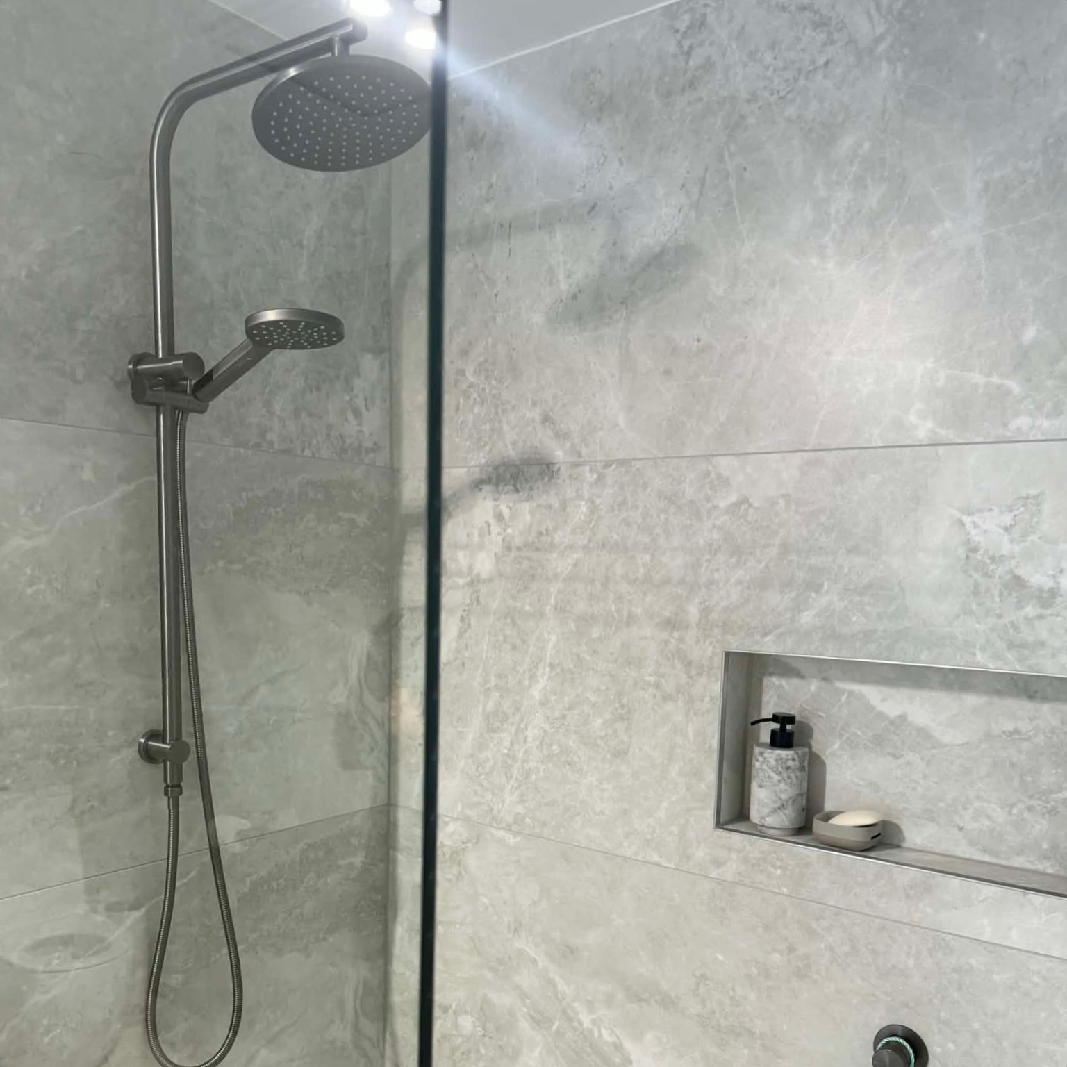 Marble-look shower with brushed nickel rail