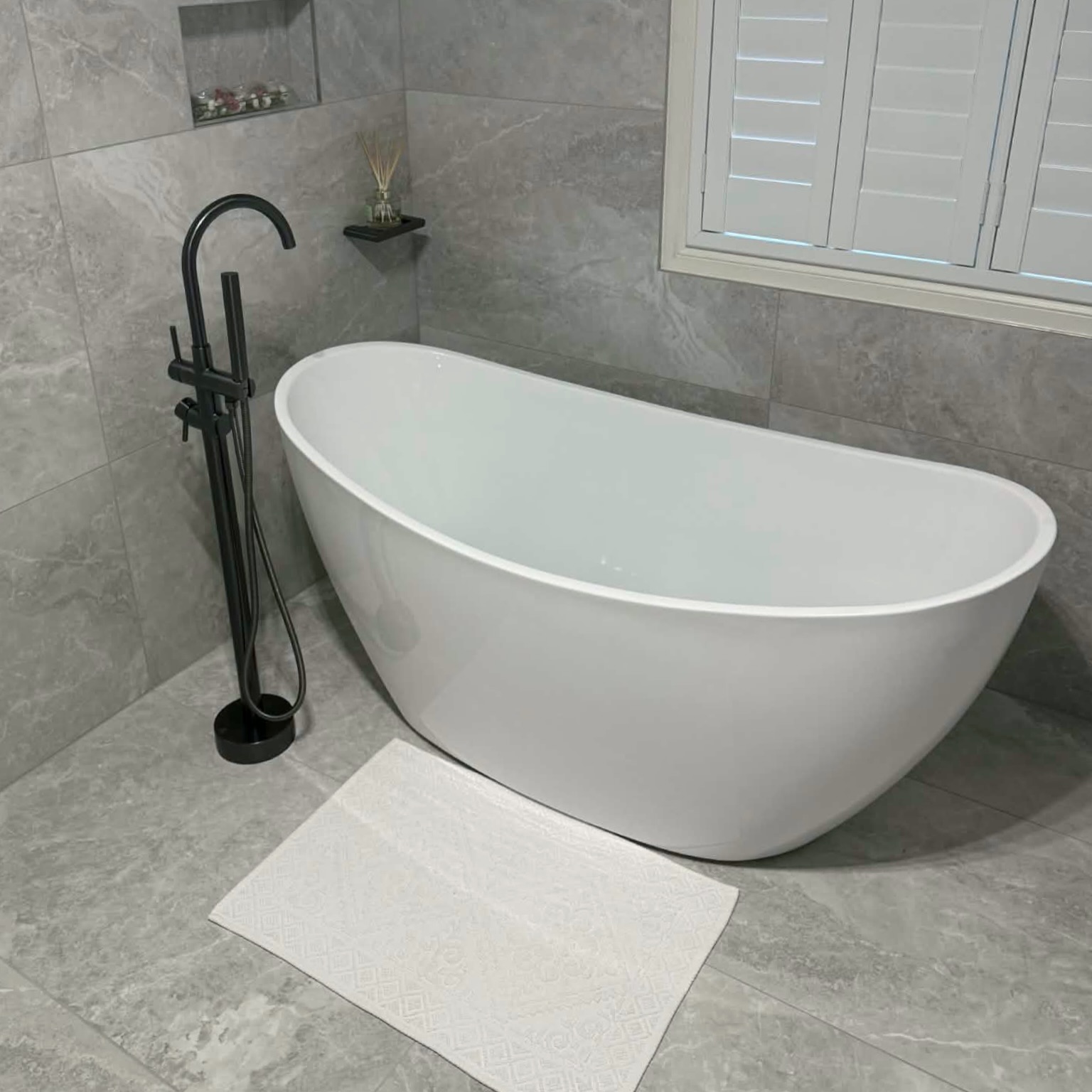 Freestanding bath with matte black floor mixer